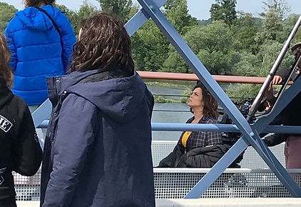 Assise sur un fauteuil, entre deux prises, Lola Dewaere observe la mise en place d'une petite plateforme sur la passerelle.